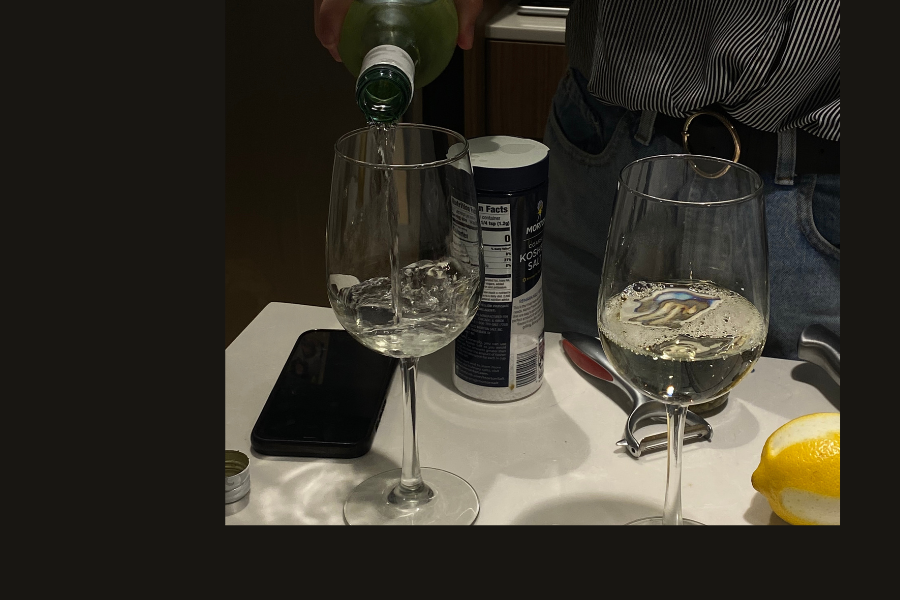 two wine glasses being filled with wine, sharing