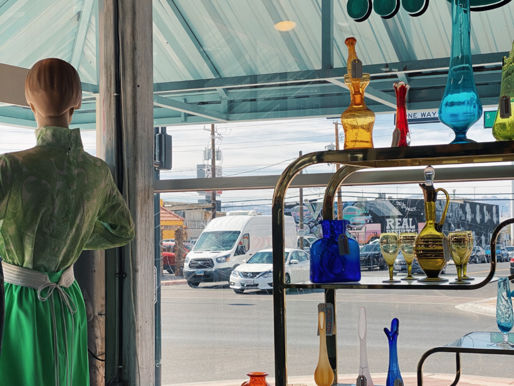 glass art and mannequin in front of a window of a street, clean girl